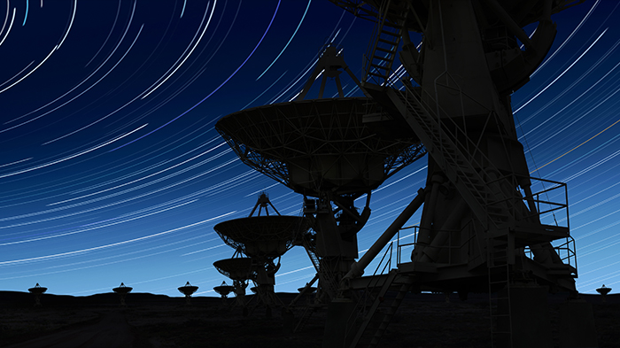 image d'antennes satellites pointées vers un ciel nocturne