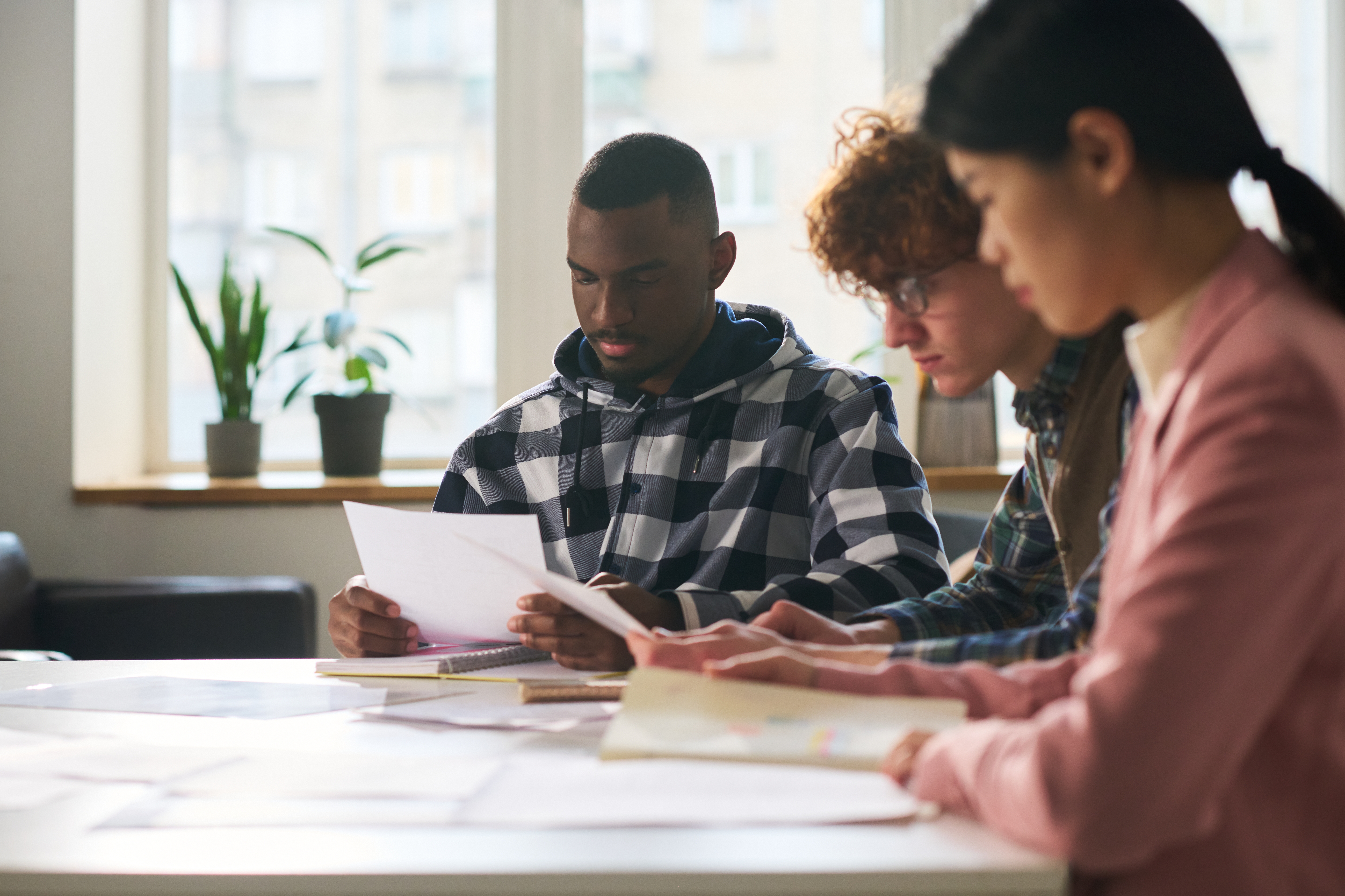 Groupe d'étudiants assis, qui révisent ensemble