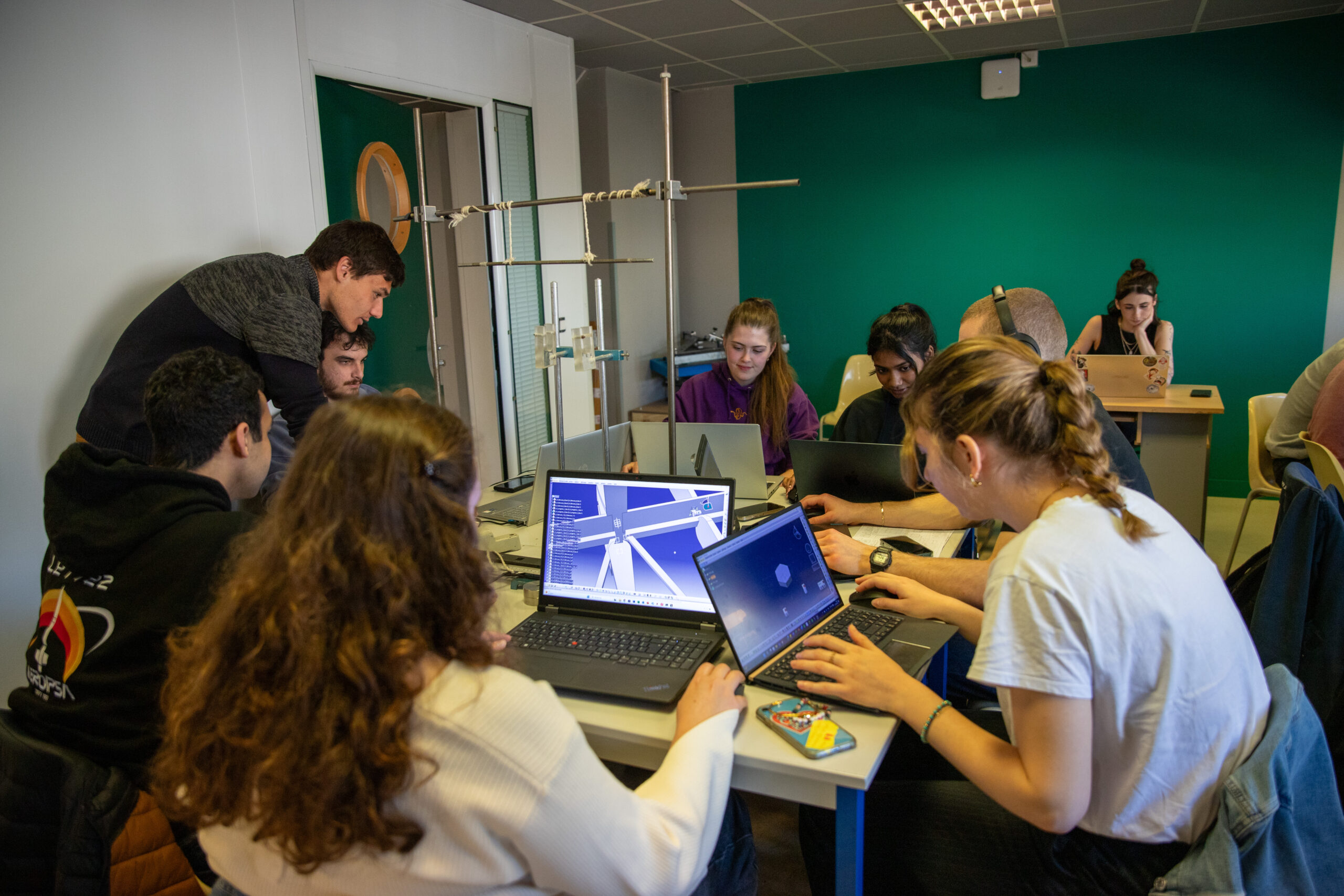 Des étudiants travaillent dans une salle de classe, leurs écrans d'ordinateurs montrent des modélisations