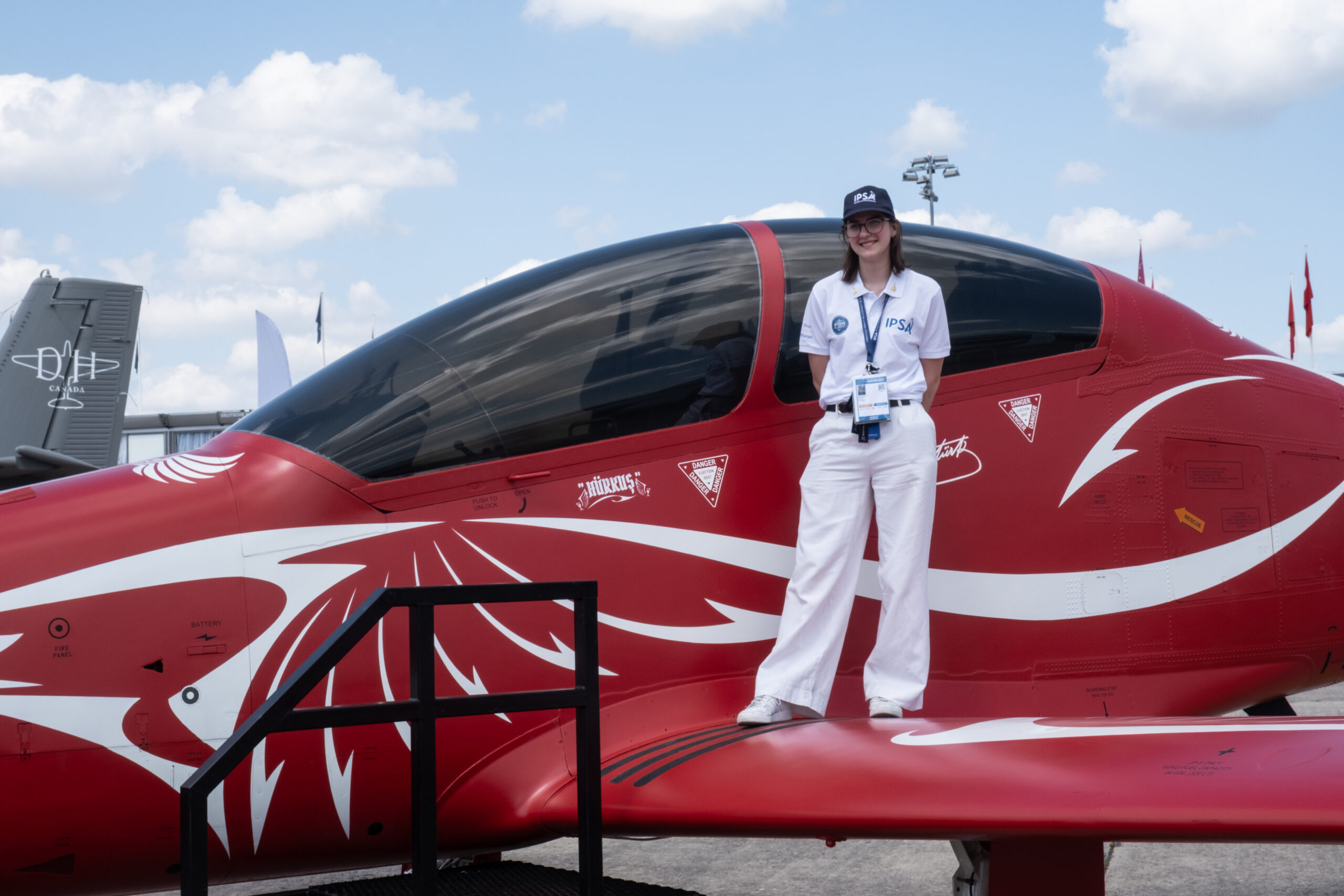 Une étudiante de l'IPSA qui pose fièrement devant un avion au Salon du Bourget