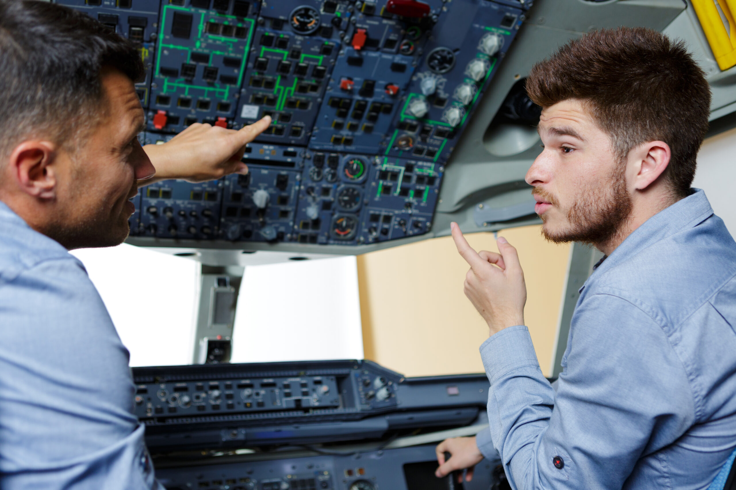 2 hommes qui discutent devant un ordinateur et dans un cockpit