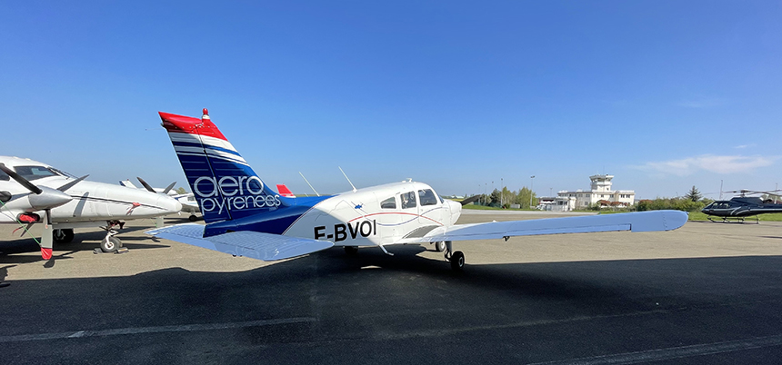 Avion avec le logo de Aéropyréenées sur le tarmac. 